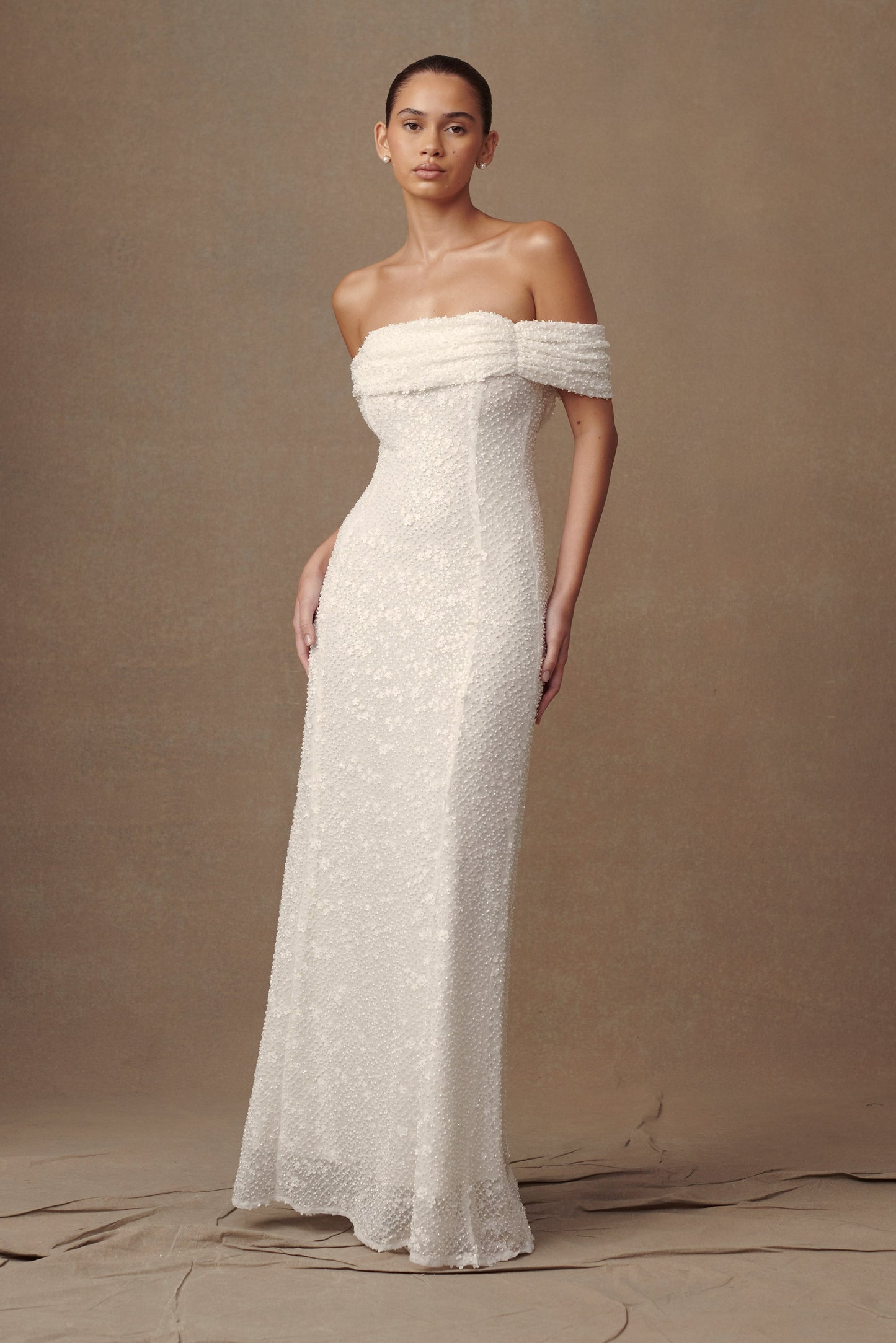 Robe de mariée blanche Priyanka Daisy, perlée et décolletée épaules dénudées.