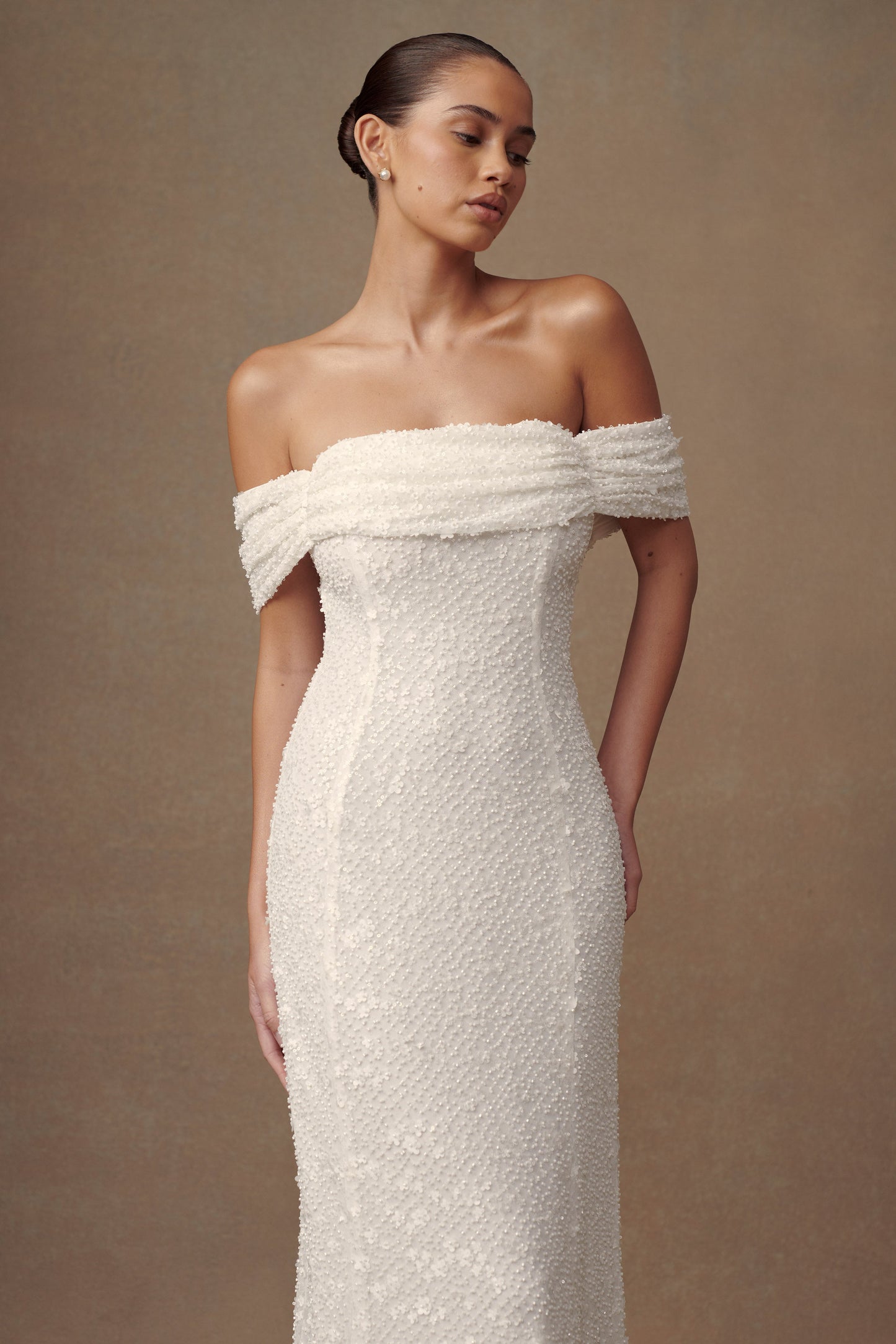 Robe de mariée blanche Priyanka Daisy, perlée et décolletée épaules dénudées.