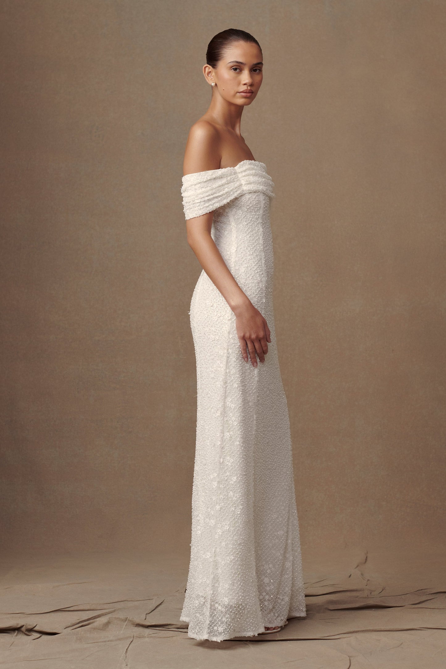 Robe de mariée blanche Priyanka Daisy, perlée et décolletée épaules dénudées.