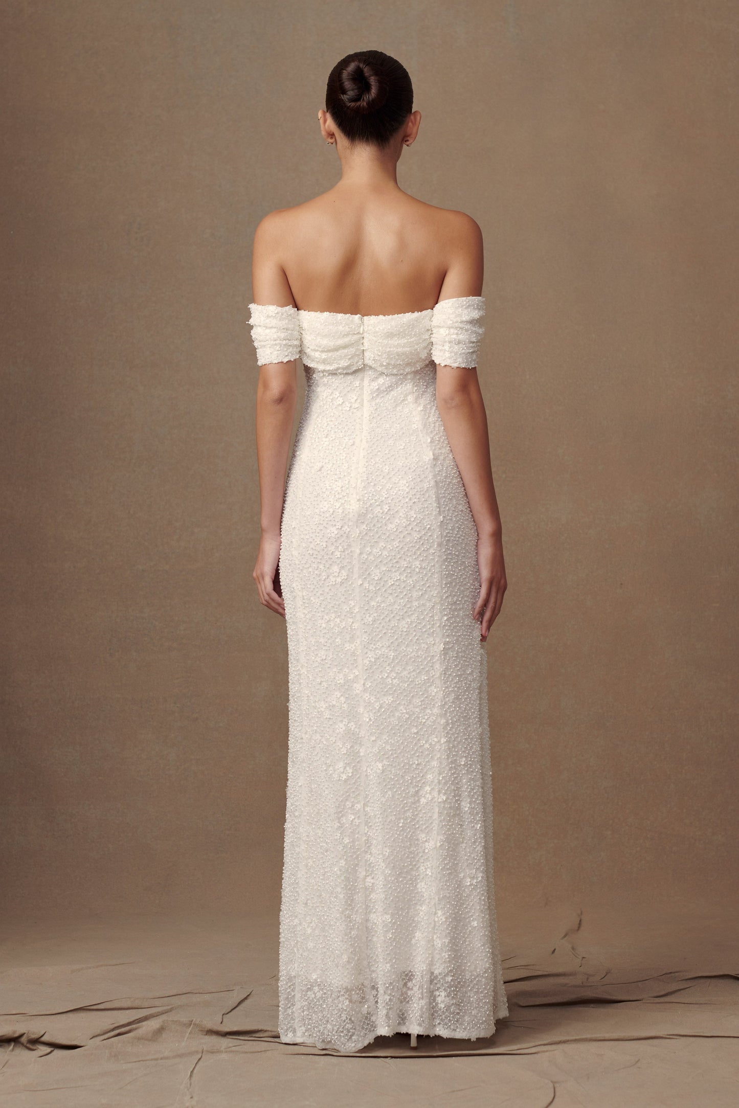 Robe de mariée blanche Priyanka Daisy, perlée et décolletée épaules dénudées.
