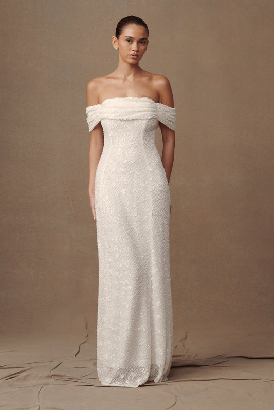 Robe de mariée blanche Priyanka Daisy, perlée et décolletée épaules dénudées.