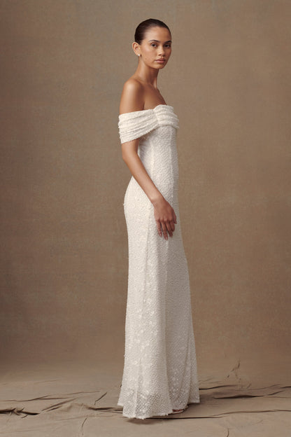 Robe de mariée blanche Priyanka Daisy, perlée et décolletée épaules dénudées.